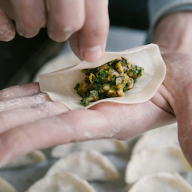 A person is showing the filling of a dumpling in his hand