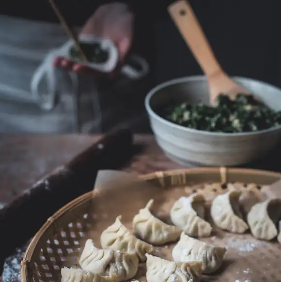  A girl is making dumplings, and the dumplings and fillings she made are on the